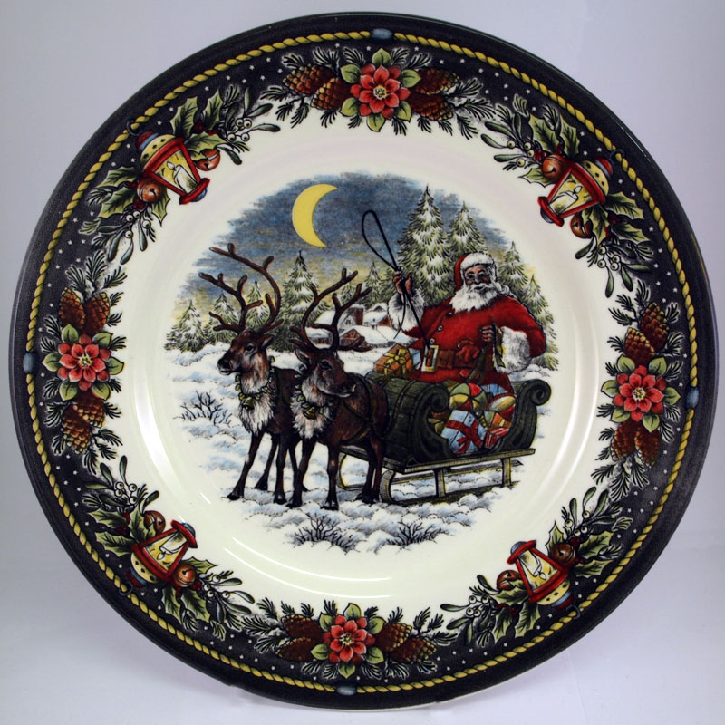 Christmas Sleigh dinner plate shows a vibrant illustration of a jolly Santa with two reindeer delivering presents on a snowy evening.